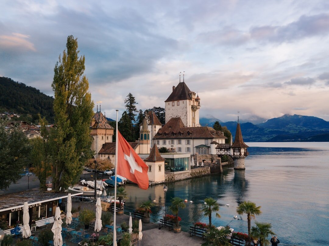 Luxury lakeside hotel terrace with white umbrellas overlooking a Swiss lake