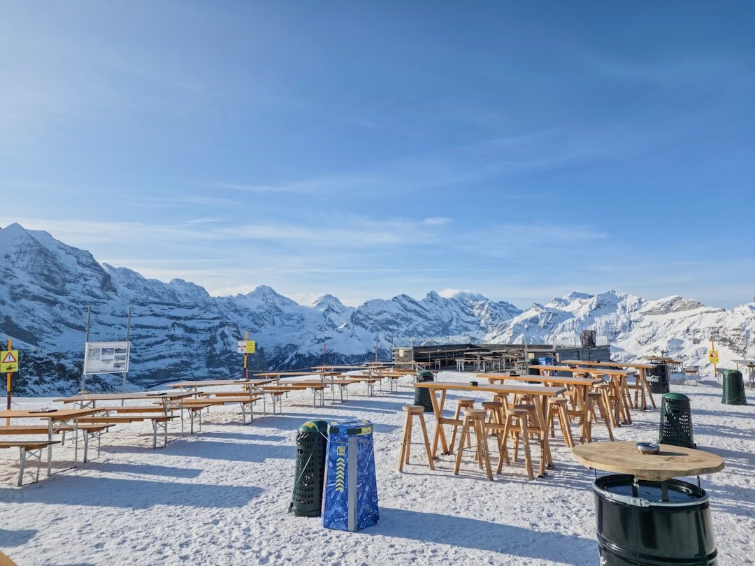 Cozy alpine restaurant terrace with wooden furniture and mountain view