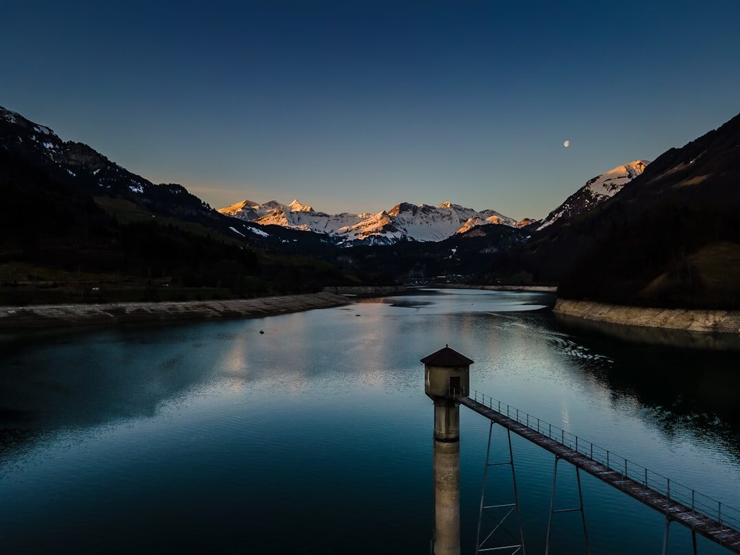 Sunlit lakeside promenade in the Swiss Alps with mountains in the background